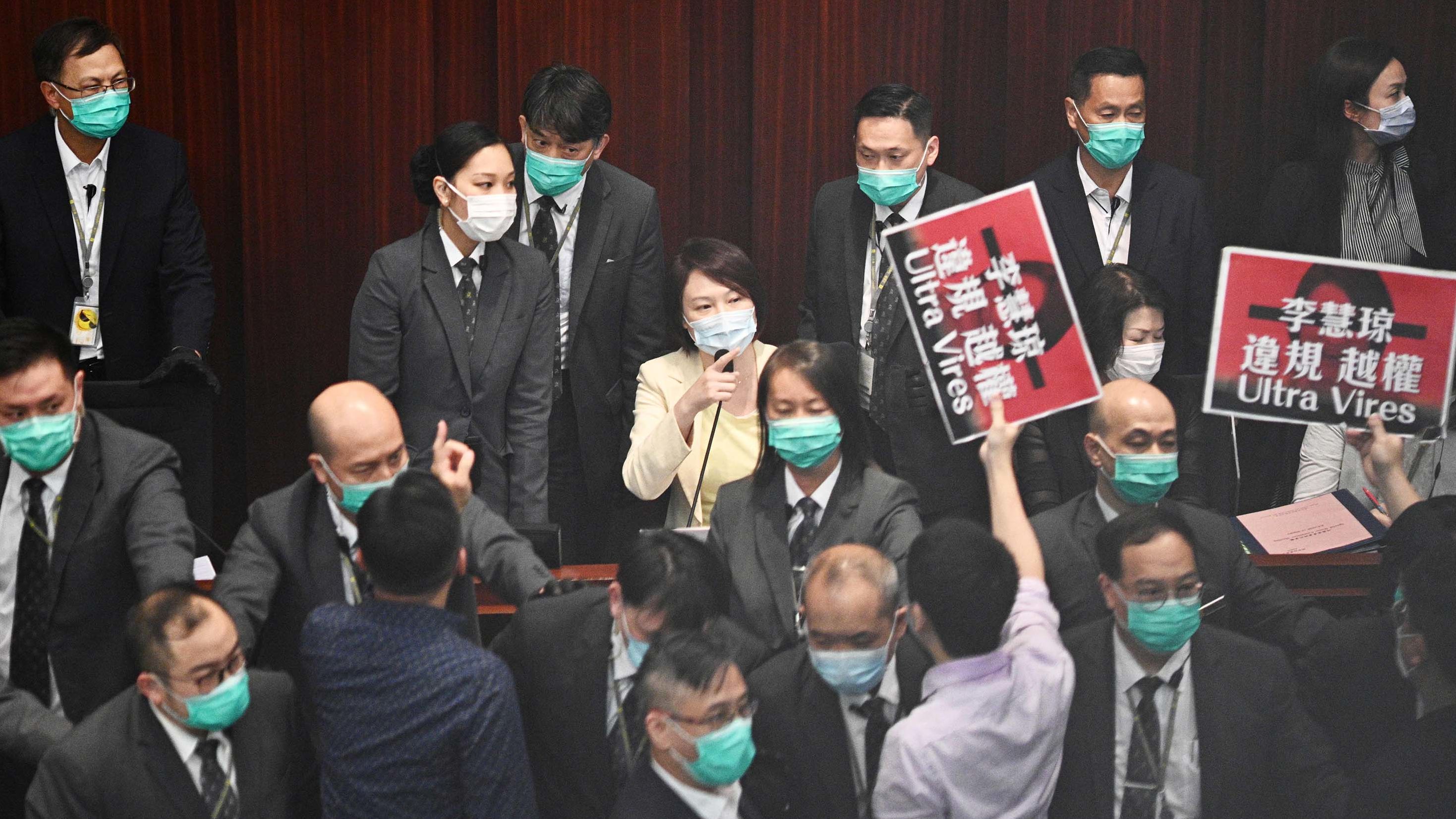 Pro-Beijing lawmaker Starry Lee, center, gestures towards pro-democracy lawmakers.