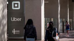 Pedestrian pass in front of signage displayed outside Uber Technologies headquarters in San Francisco, California, U.S., on Monday, May 4, 2020. Lyft Inc. withdrew its profit and revenue forecasts for 2020, following rival Uber Technologies Inc. in citing evolving and unpredictable impacts from Covid-19. Photographer: David Paul Morris/Bloomberg via Getty Images
