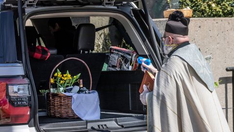 The Rev. Timothy Pelc sprayed holy water at his socially distanced parishioners.