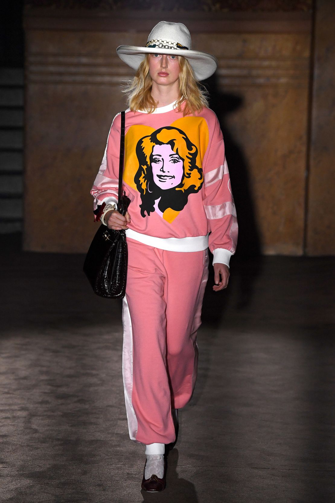 A model in a Dolly Parton portrait sweater at the Gucci show during Paris Fashion Week Spring-Summer 2019 