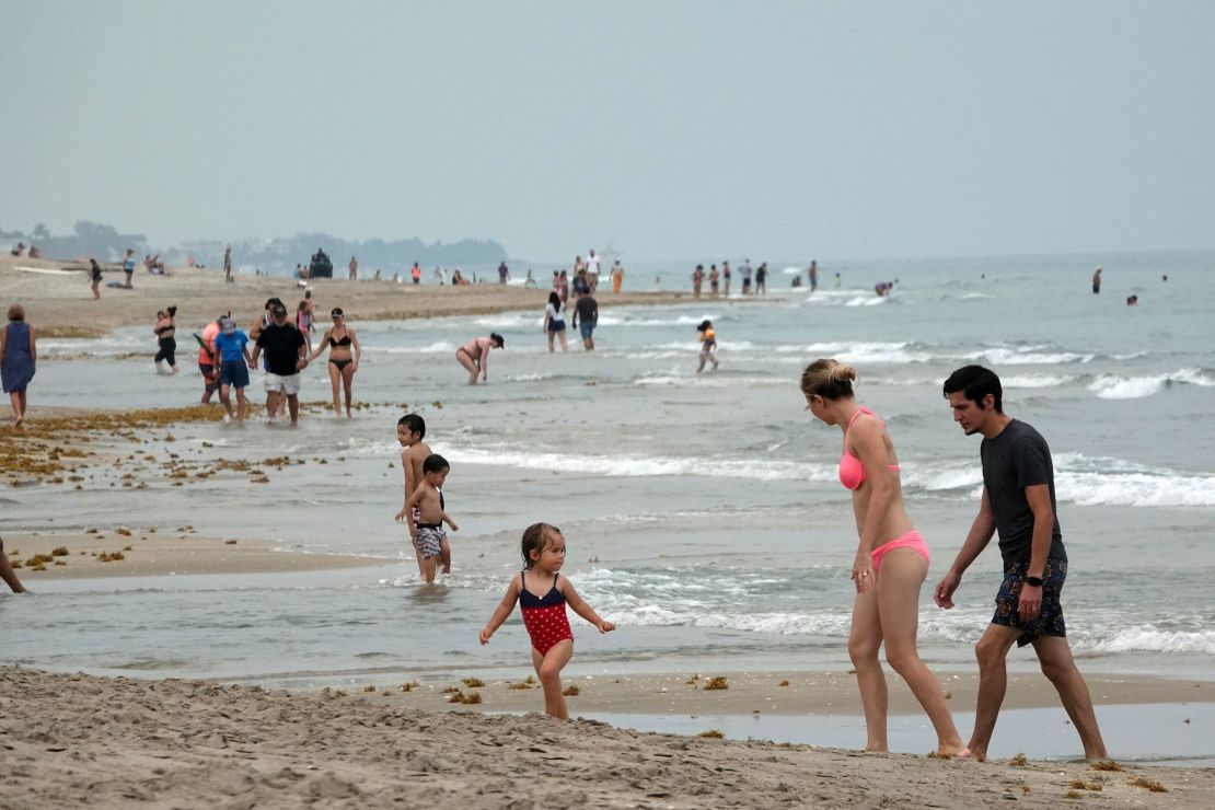 This family, visiting Florida's Delray Beach earlier this month, is keeping their distance from others, as infectious disease experts suggest.