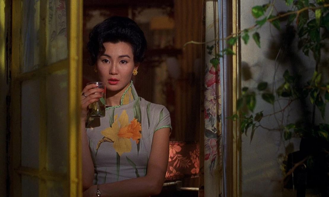 The costumes often mirror the surroundings, such as this scene where Mrs. Chan's daffodil print dress stands out among other floral motifs.
