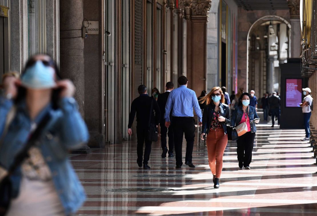 People walk across a shopping colonnade in Milan on May 18.