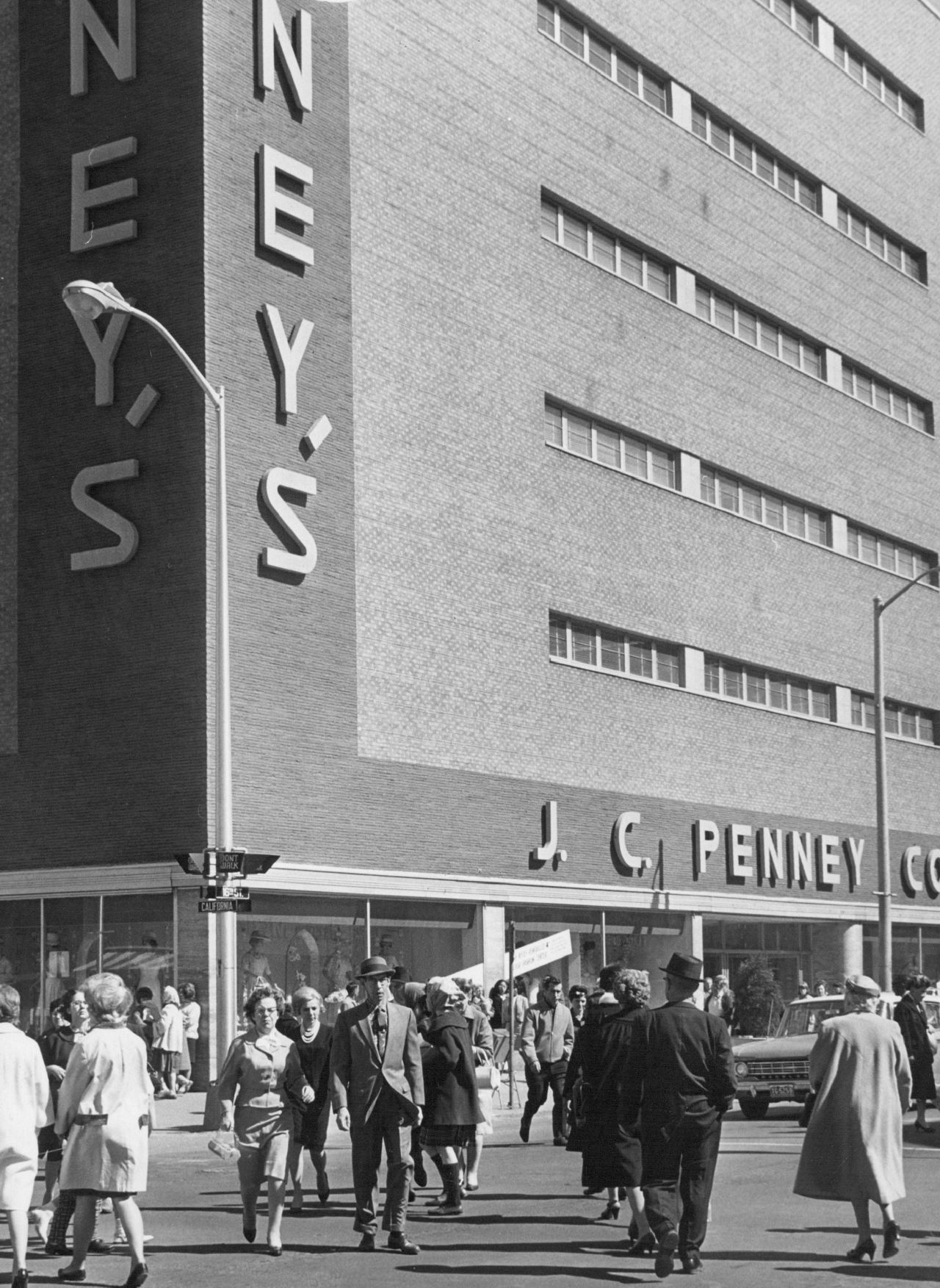 Shoppers hurry across an intersection in front of a JCPenney store in Denver in 1964.