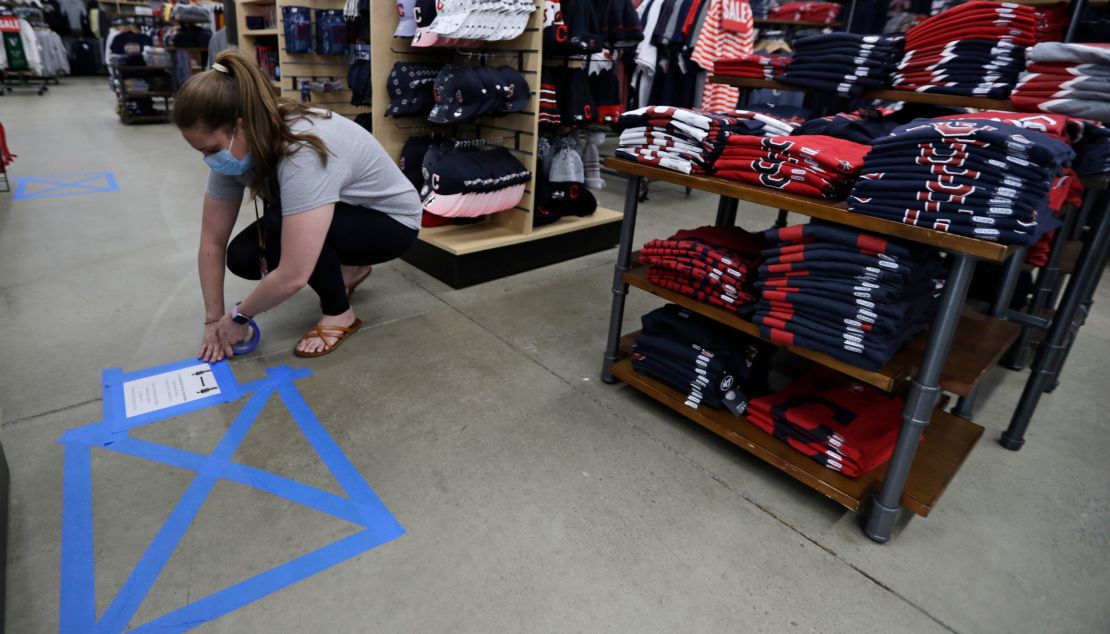 A store manager in Mayfield Heights, Ohio, puts social distancing guidelines in place at Rally House on May 11.