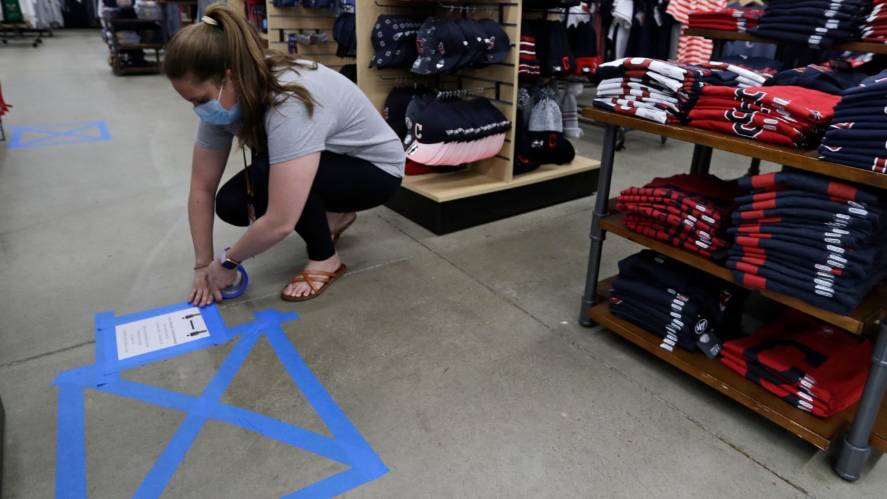 A store manager in Mayfield Heights, Ohio, puts social distancing guidelines in place at Rally House on May 11.