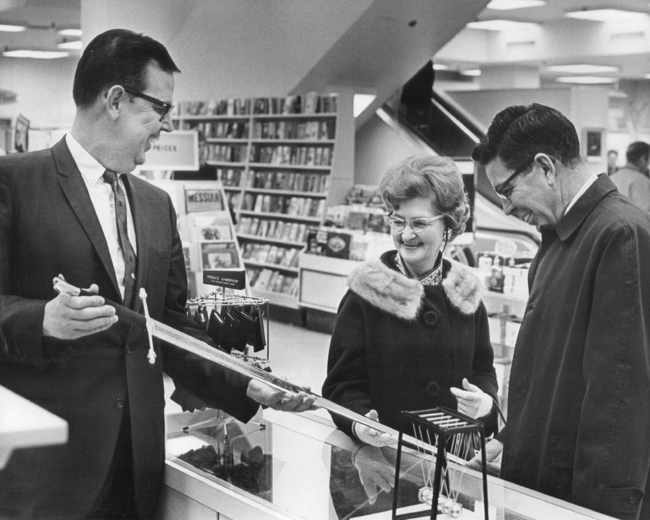 Russell Martin, a store manager in Denver, shows a sword to a couple that won it as a special promotion in 1968.