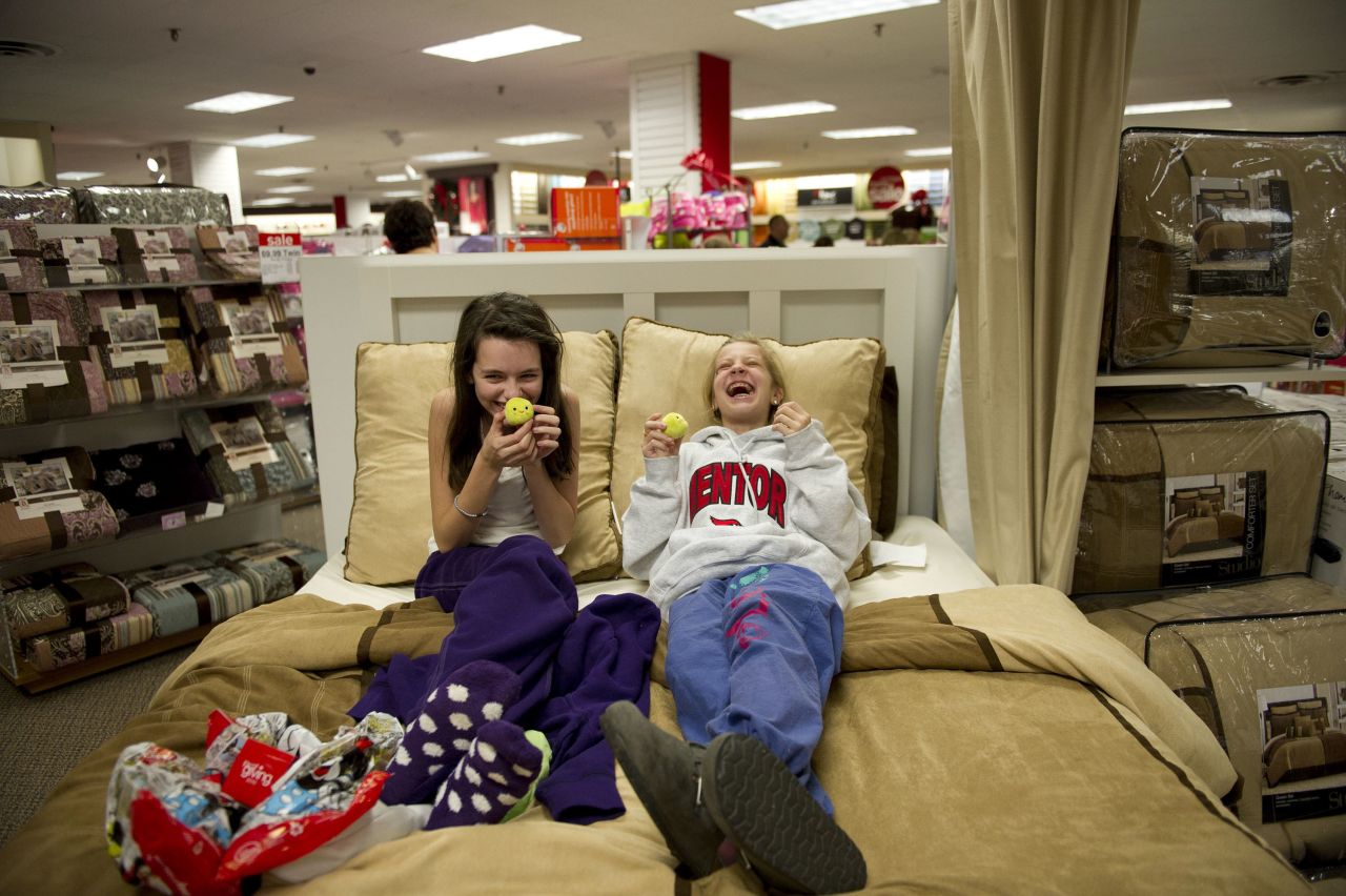 Gabbie Juka, left, and Allison Funk share a laugh as they relax on a bed at a JCPenney store in Mentor, Ohio, in 2010.