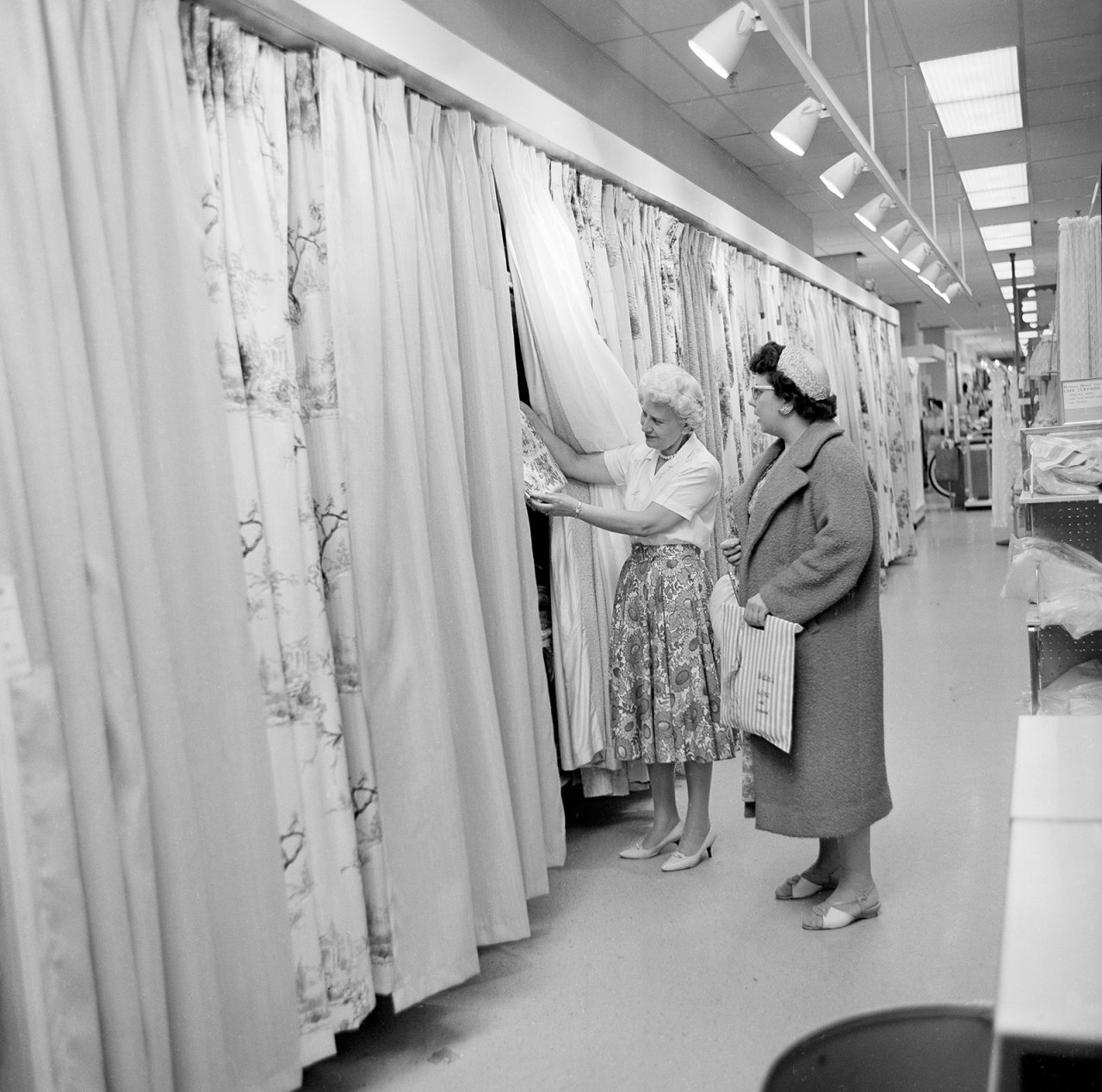 Sales clerk Lucille Jagusch shows drapery samples to shopper Arlene Hardt at a Sears store in Niles, Illinois, in 1961.