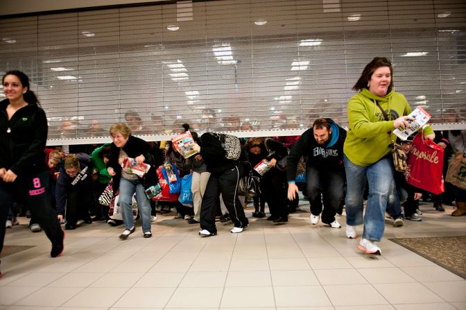 Black Friday shoppers duck under the opening door of a Sears store in Mentor, Ohio, in 2011.