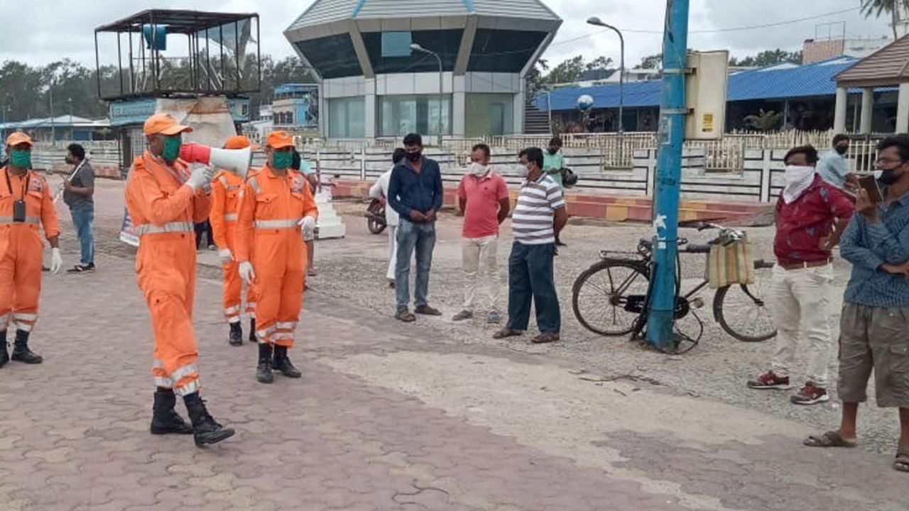 Members of India's National Disaster Response Force warn people on the Bay of Bengal coast at Namkhana, West Bengal, on May 19