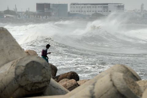 A man looks out at waves in Chennai, India, on May 19.