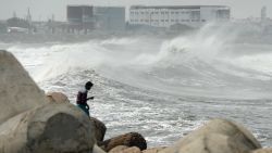 A man looks out as waves hit a breakwater at Kasimedu fishing harbour in Chennai on May 19, 2020, as Cyclone Amphan barrels towards India's eastern coast. - Millions of people were being moved to safety on May 19 as one of the fiercest cyclones in decades barrelled towards India and Bangladesh, with evacuation plans complicated by coronavirus precautions. Both countries are under various stages of lockdown because of the disease, with infections still surging. (Photo by Arun SANKAR / AFP) (Photo by ARUN SANKAR/AFP via Getty Images)