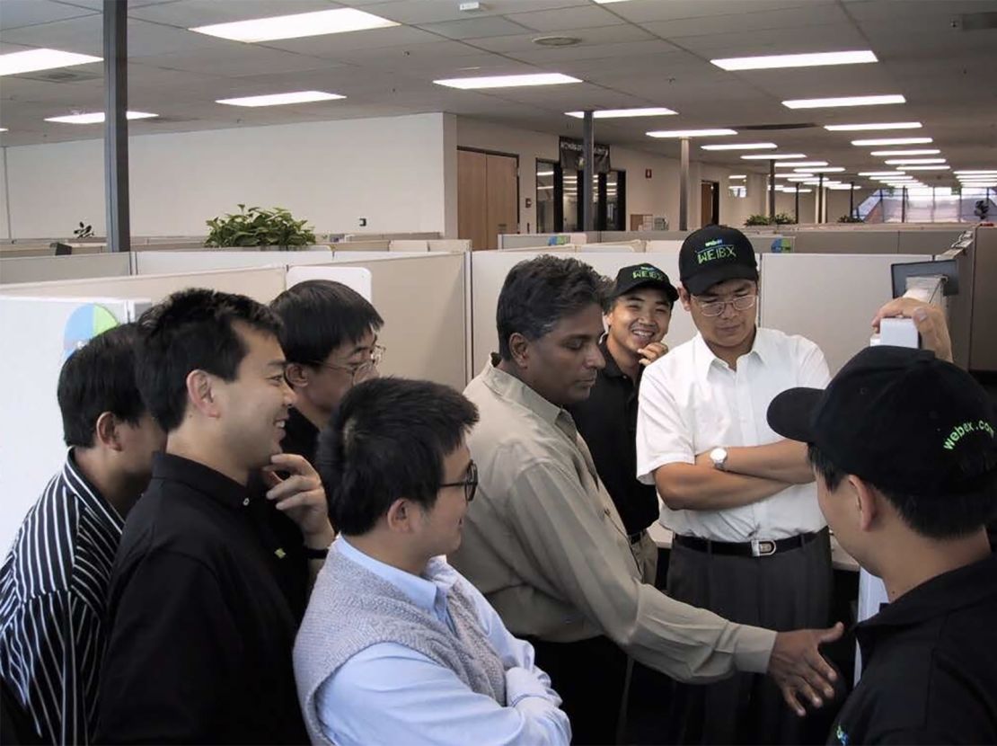 The WebEx team celebrates their IPO in 2000. WebEx cofounder Subrah Iyar, in a greige shirt, is flanked by Eric Yuan in a black polo shirt and hat. Yuan was an engineer for the company at the time. (Photo courtesy of Subrah Iyar)