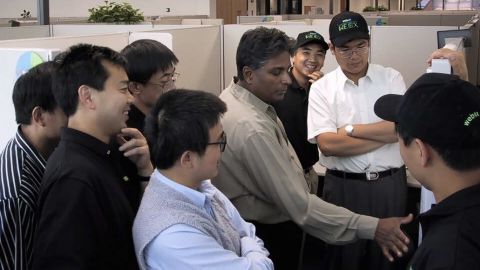 The WebEx team celebrates their IPO in 2000. WebEx cofounder Subrah Iyar, in a greige shirt, is flanked by Eric Yuan in a black polo shirt and hat. Yuan was an engineer for the company at the time. (Photo courtesy of Subrah Iyar)