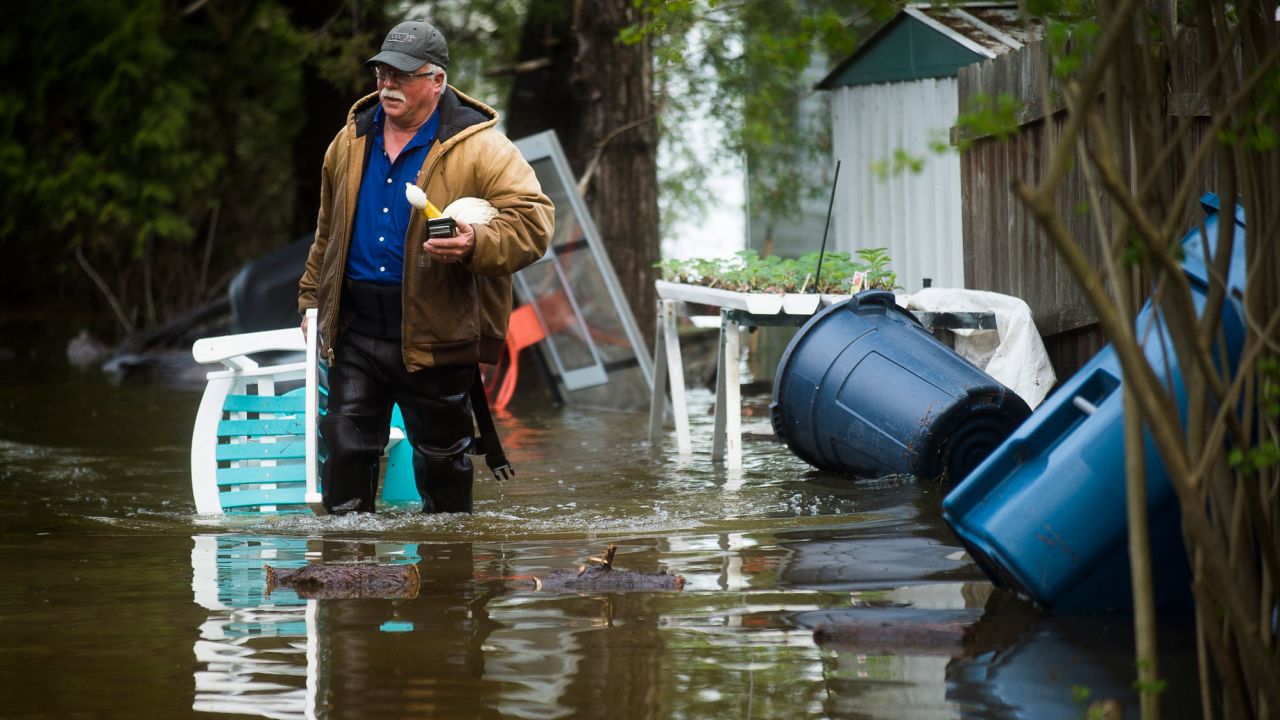 Mark Musselman brings a chair to the front of his house on Tuesday in Edenville, Michigan.