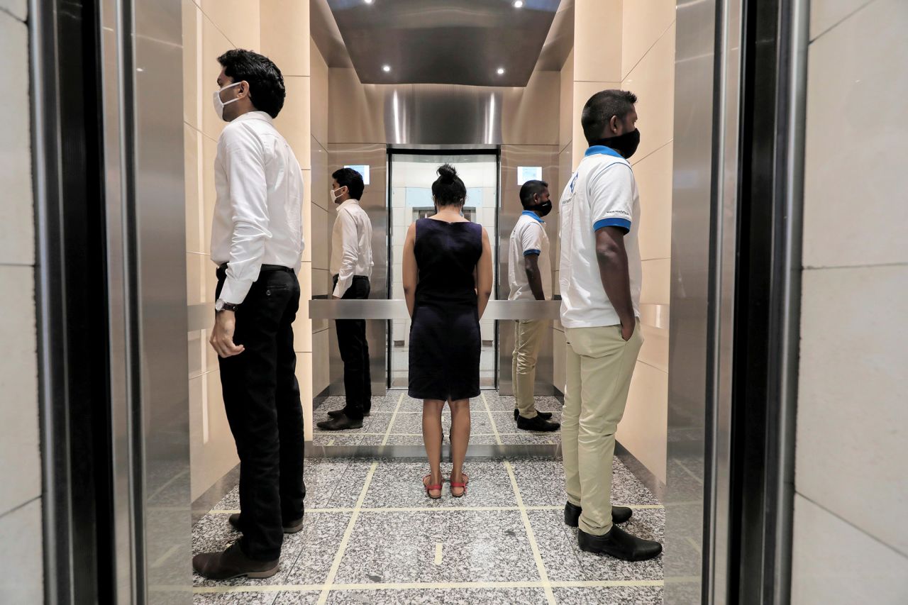 People in an elevator stand away from one another as they arrive to work at the World Trade Center in Colombo, Sri Lanka, on May 11.