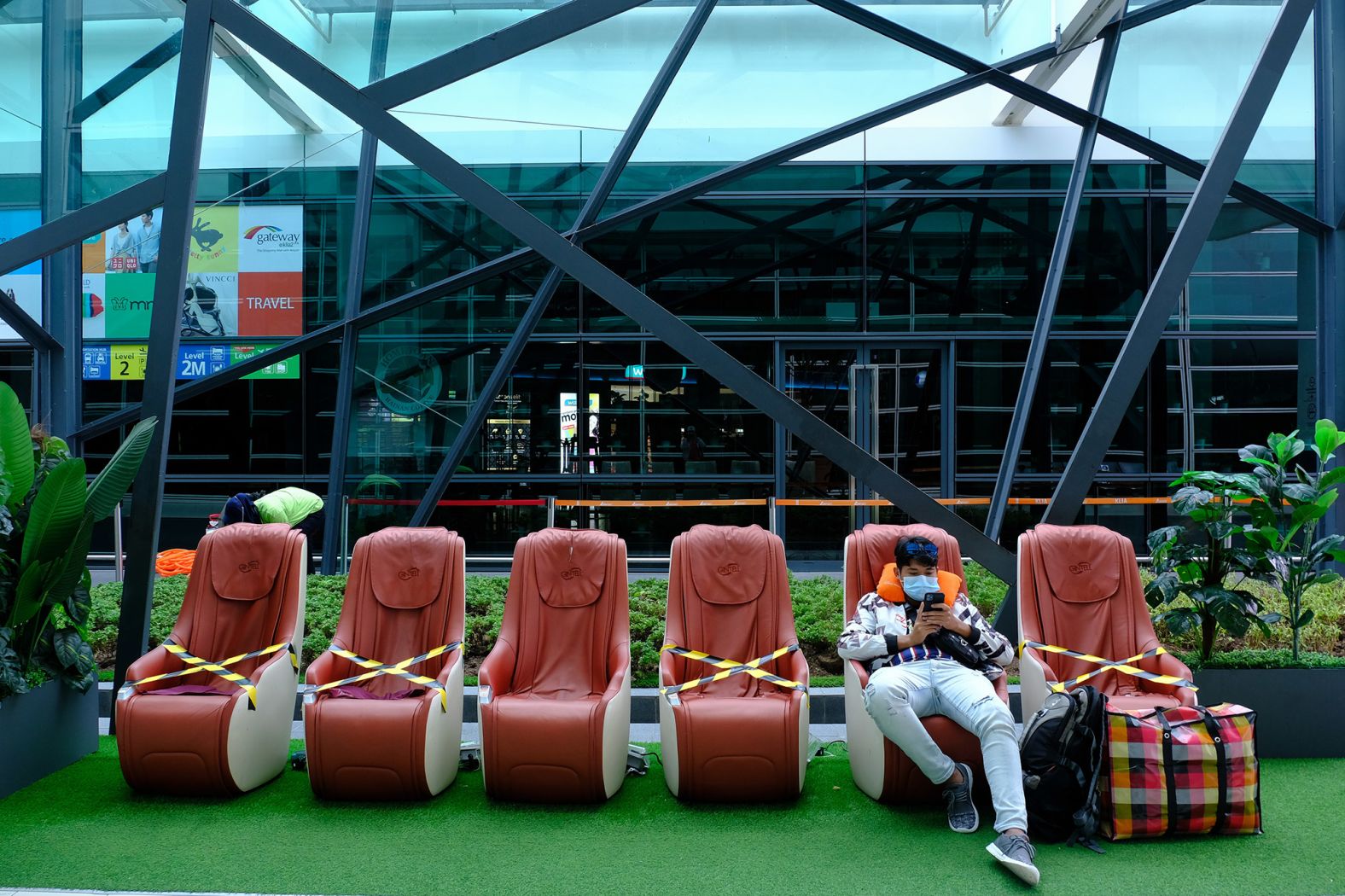 A traveler sits next to chairs with social-distancing markers on them inside Malaysia's Kuala Lumpur International Airport on May 13.