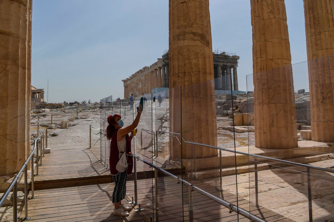 A woman cleans a divider at the entrance of the Acropolis in Athens, Greece, on May 18. Greece reopened all open-air archaeological sites in the country after a two-month closure.