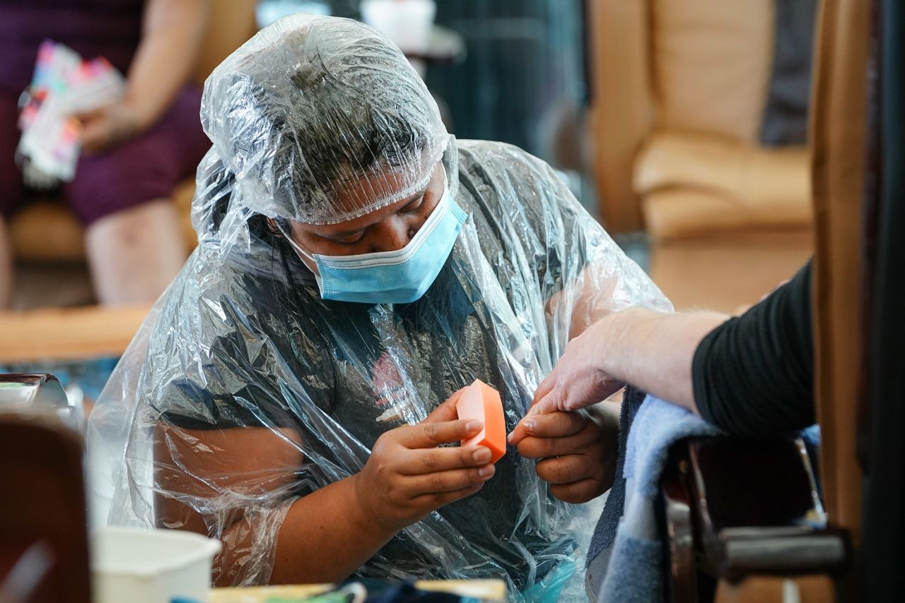 A customer gets a manicure at a nail salon in Atlanta on April 24. Georgia's hair salons, tattoo parlors, bowling alleys and other businesses were permitted to reopen after Gov. Brian Kemp announced that he'd ease the state's stay-at-home order.