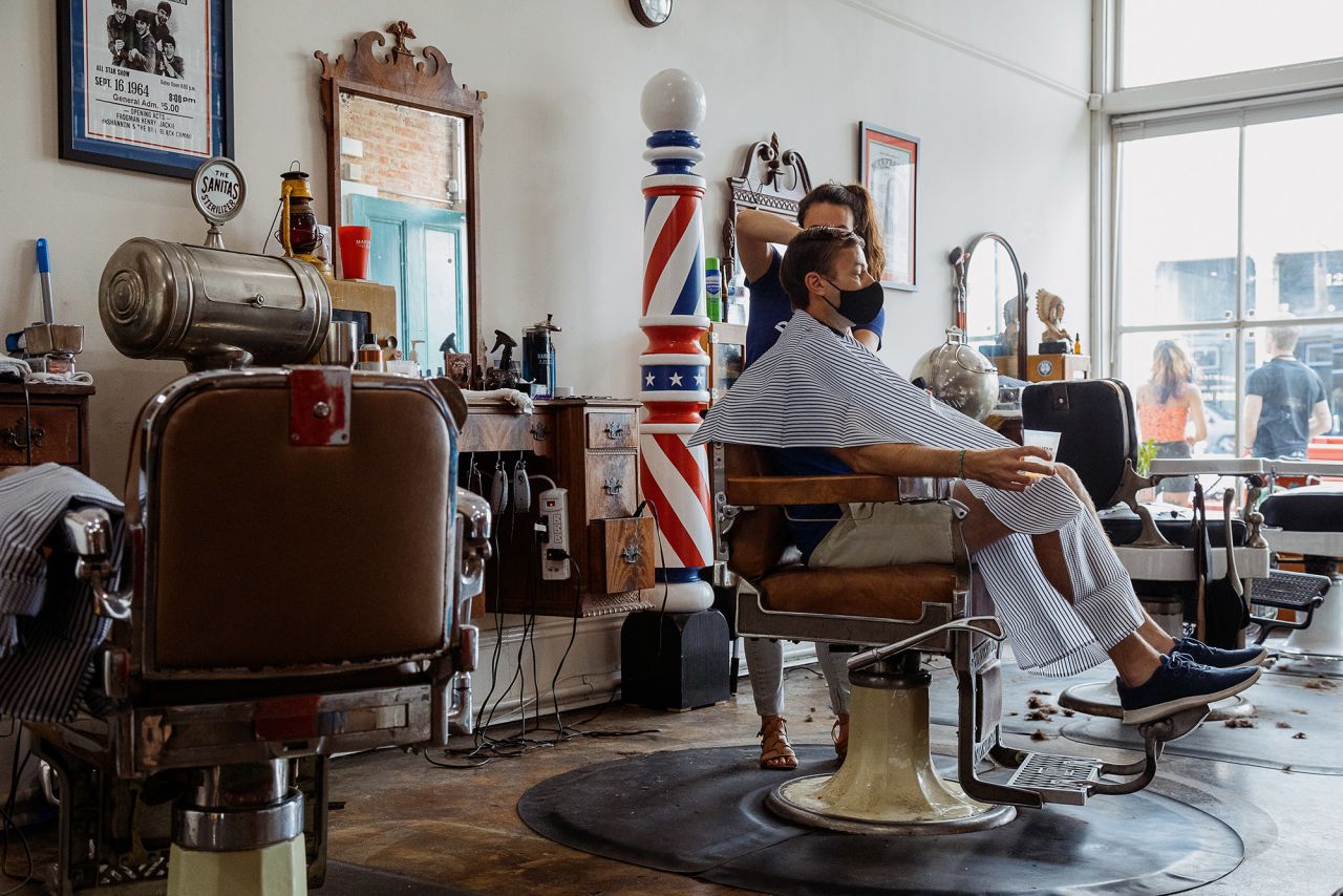 A stylist cuts a customer's hair at a barbershop in New Orleans on May 16. Louisiana Gov. John Bel Edwards loosened restrictions on certain businesses in the state.