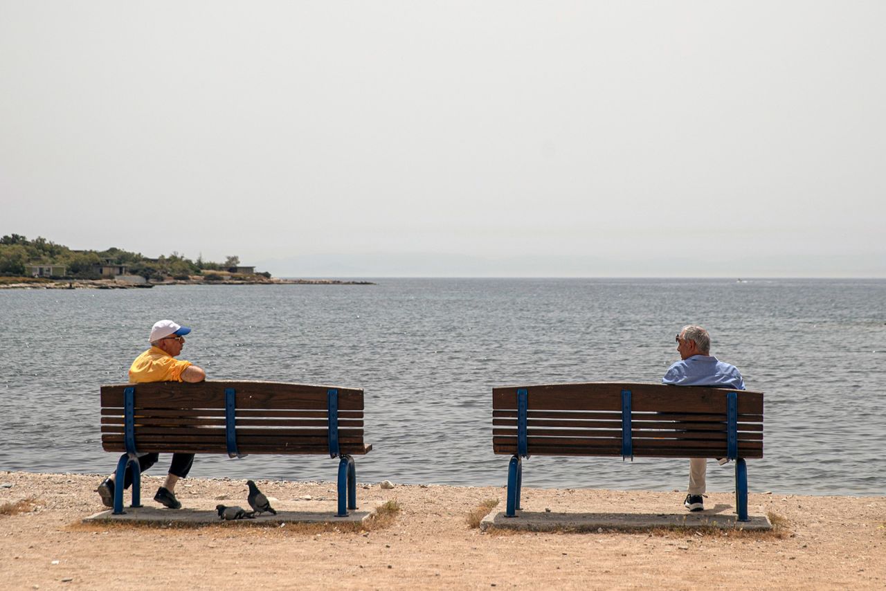 Men maintain their distance from each other while speaking in Glyfada, Greece, on May 15.