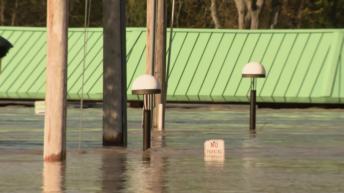 Floodwaters flow through a part of downtown Midland on Wednesday morning, close to a farmers' market with a green roof.