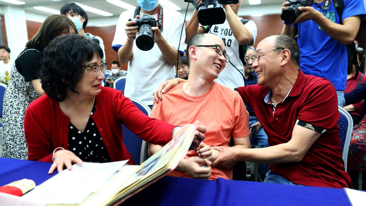 Mao Yin goes through a photo album with his mother Li Jingzhi and father Mao Zhenping following their reunion on Monday.