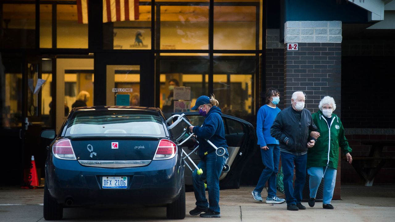 People stand outside a shelter at Meridian Junior High School, in Sanford, Michigan, this week.