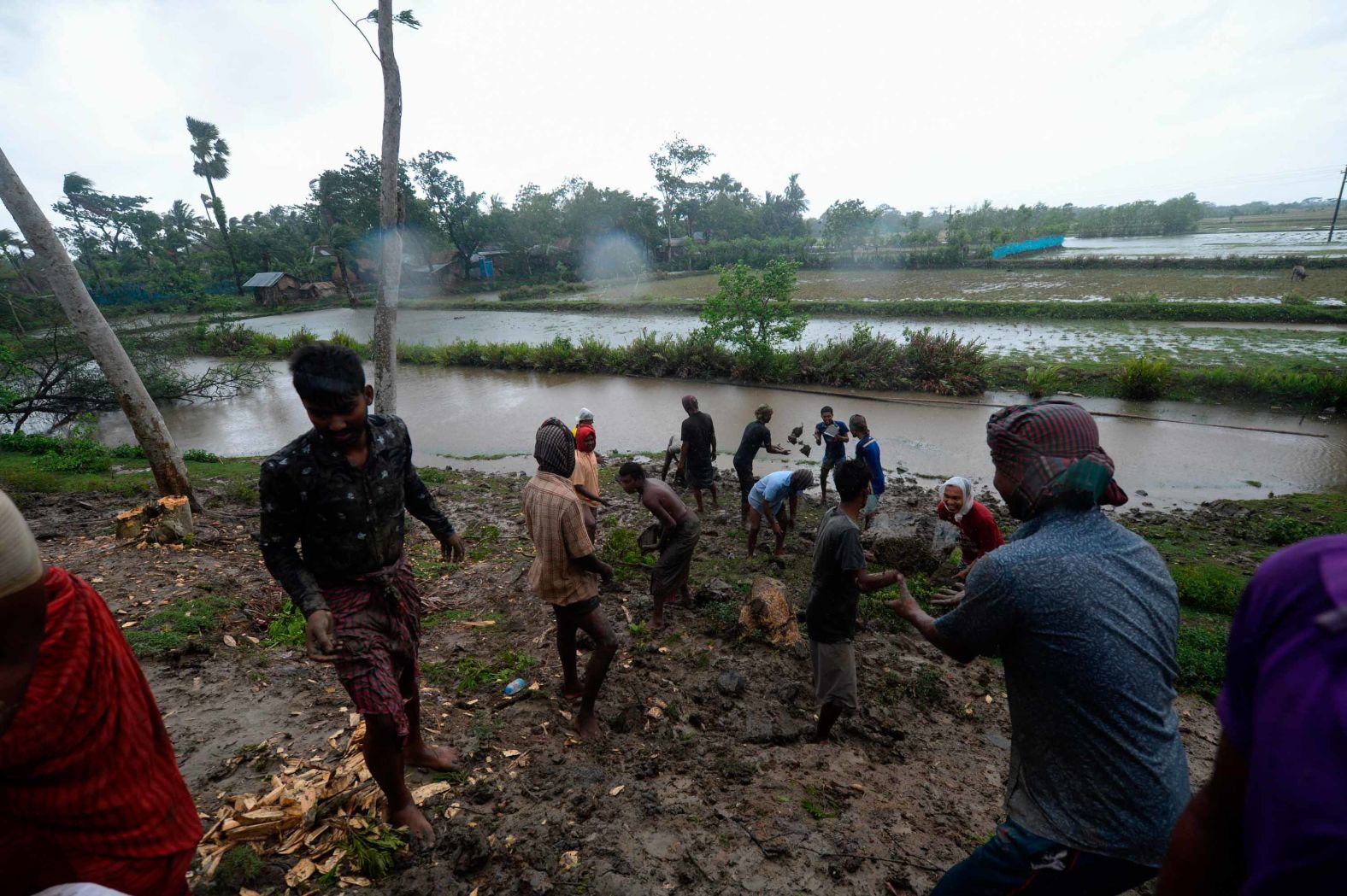Villagers reinforce an embankment with sacks of soil in Dacope.