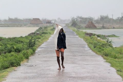 A man walks in the rain in India's Bhadrak district.