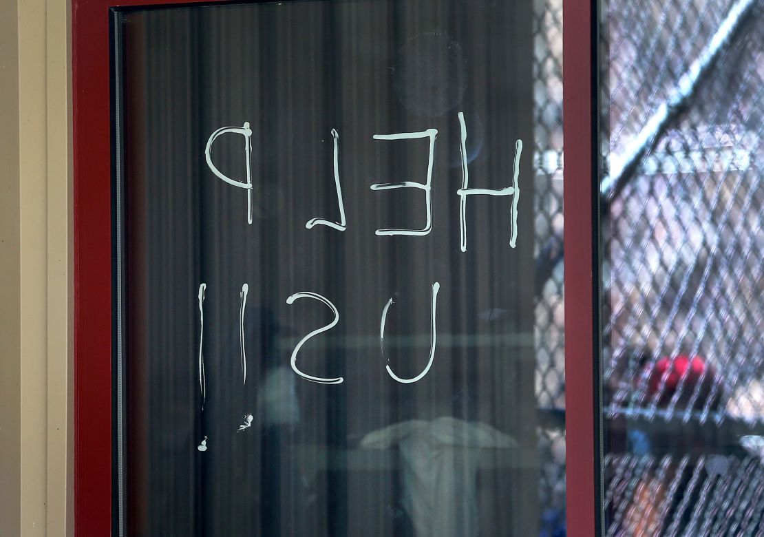 "Help us" is seen written on a window at an ICE facility at the Bristol County Sheriff's correctional complex on May 2, 2020.