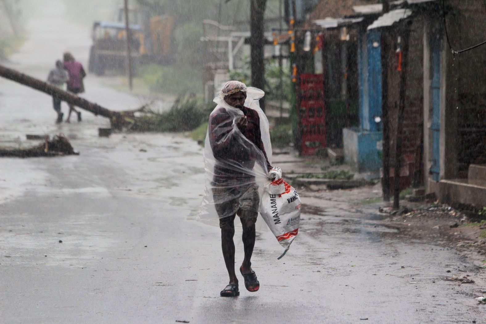 A man covers himself with plastic in India's Bhadrak district.