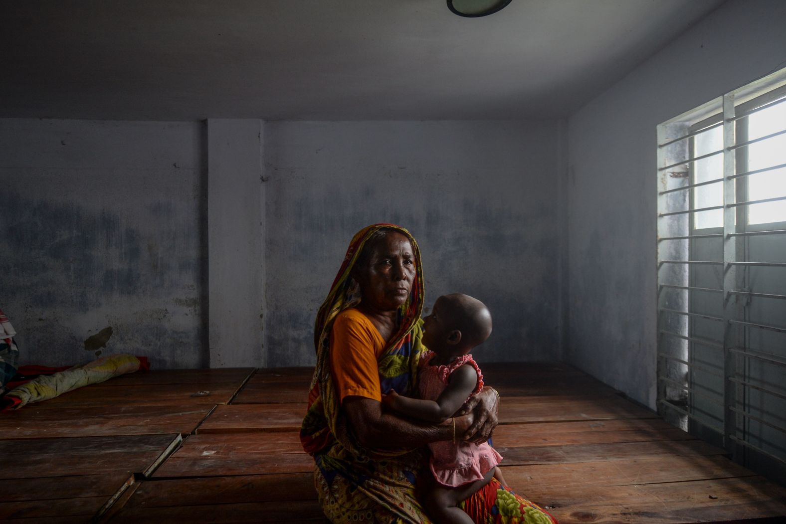 A resident rests in a Dacope shelter ahead of the cyclone's expected landfall.