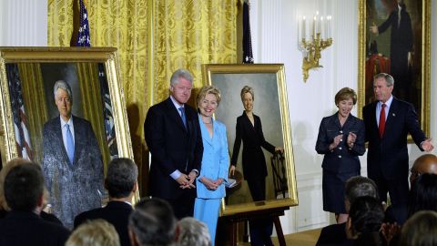 Former President Bill Clinton and former first lady Hillary Clinton stand by their offical White House portraits during the unveiling event hosted by then-President George W. Bush and first lady Laura Bush in June 2004 at the White House.