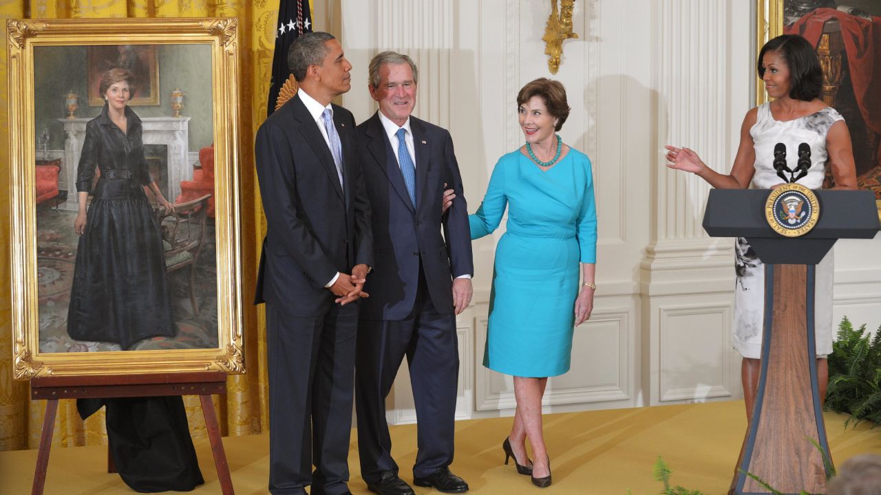 Michelle Obama speaks as then-President Barack Obama, former President George W. Bush and his wife, former first lady Laura Bush, look on during the unveiling of the Bushes' portraits in the East Room of the White House in May 2012.