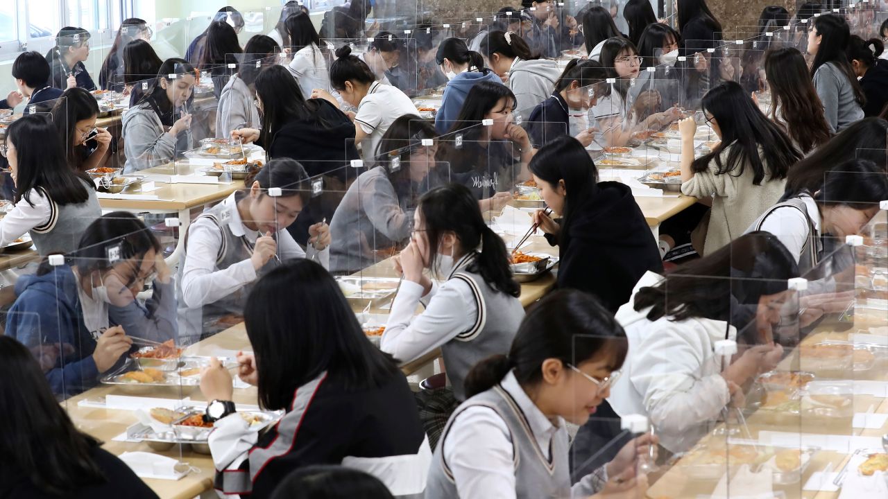 Senior students eat lunch at tables equipped with plastic barriers to prevent possible spread of coronavirus in the cafeteria at Jeonmin High School in Daejeon, South Korea, Wednesday, May 20, 2020.