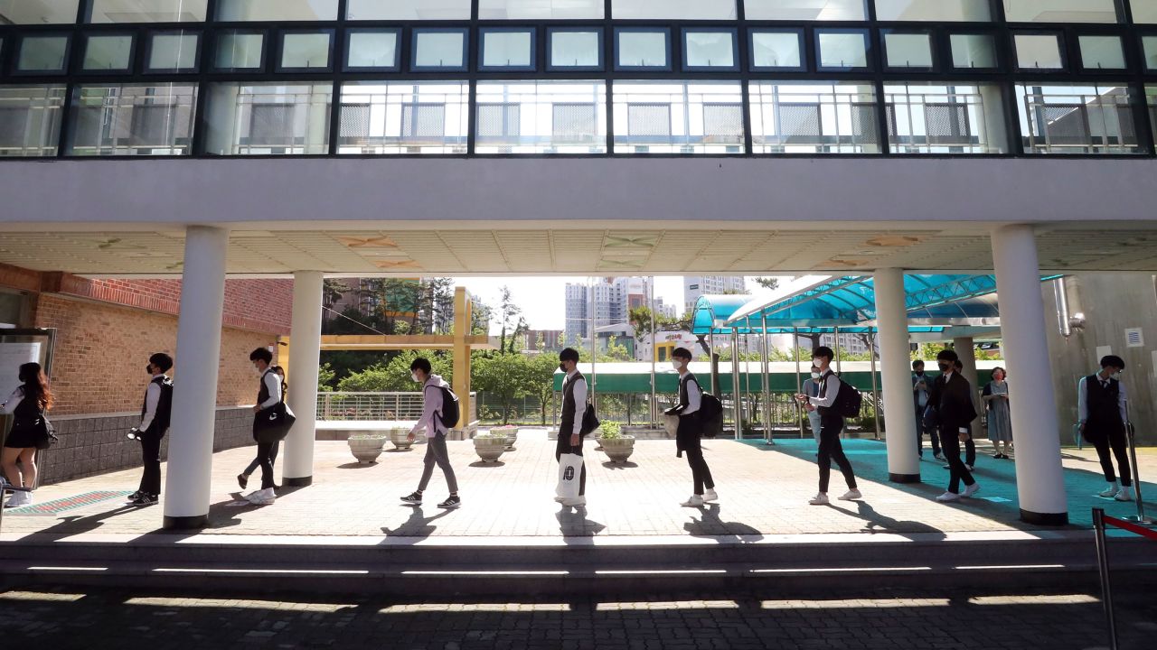 Senior students maintain social distancing as they arrive at Hamwol High School in Ulsan, South Korea, Wednesday, May 20, 2020.