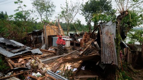 A woman stands in the debris of her house  after it was damaged by Cyclone Amphan in Satkhira, Bangladesh.