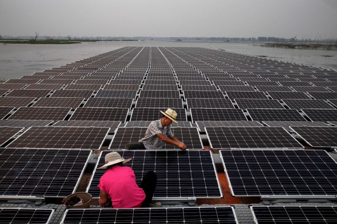 Workers prepare part of a large floating solar farm project under construction in June 2017 in Huainan, Anhui province, China.