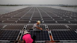 HUAINAN, CHINA - JUNE 12: Chinese workers prepare  panels that will be part of a large floating solar farm project under construction by the Sungrow Power Supply Company on a lake caused by a collapsed and flooded coal mine on June 12, 2017 in Huainan, Anhui province, China. The floating solar field, billed as the largest in the world, is built on a part of the collapsed Panji No.1 coal mine that flooded over a decade ago due to over-mining, a common occurence in deep-well mining in China's coal heartland. When finished, the solar farm will be made up of more than 166,000 solar panels which convert sunlight to energy, and the site could potentially produce enough energy to power a city in Anhui province, regarded as one of the country's coal centers. Local officials say they are planning more projects like it, marking a significant shift in an area where long-term intensive coal mining has led to large areas of subsidence and environmental degradation. However, the energy transition has its challenges, primarily competitive pressure from the deeply-established coal industry that has at times led to delays in connecting solar projects to the state grid. Chinaâs government says it will spend over US $360 billion on clean energy projects by 2020 to help shift the country away from a dependence on fossil fuels, and earlier this year, Beijing canceled plans to build more than 100 coal-fired plants in a bid to ease overcapacity and limit carbon emissions. Already, China is the leading producer of solar energy, but it also remains the planetâs top emitter of greenhouse gases and accounts for about half of the worldâs total coal consumption. (Photo by Kevin Frayer/Getty Images)