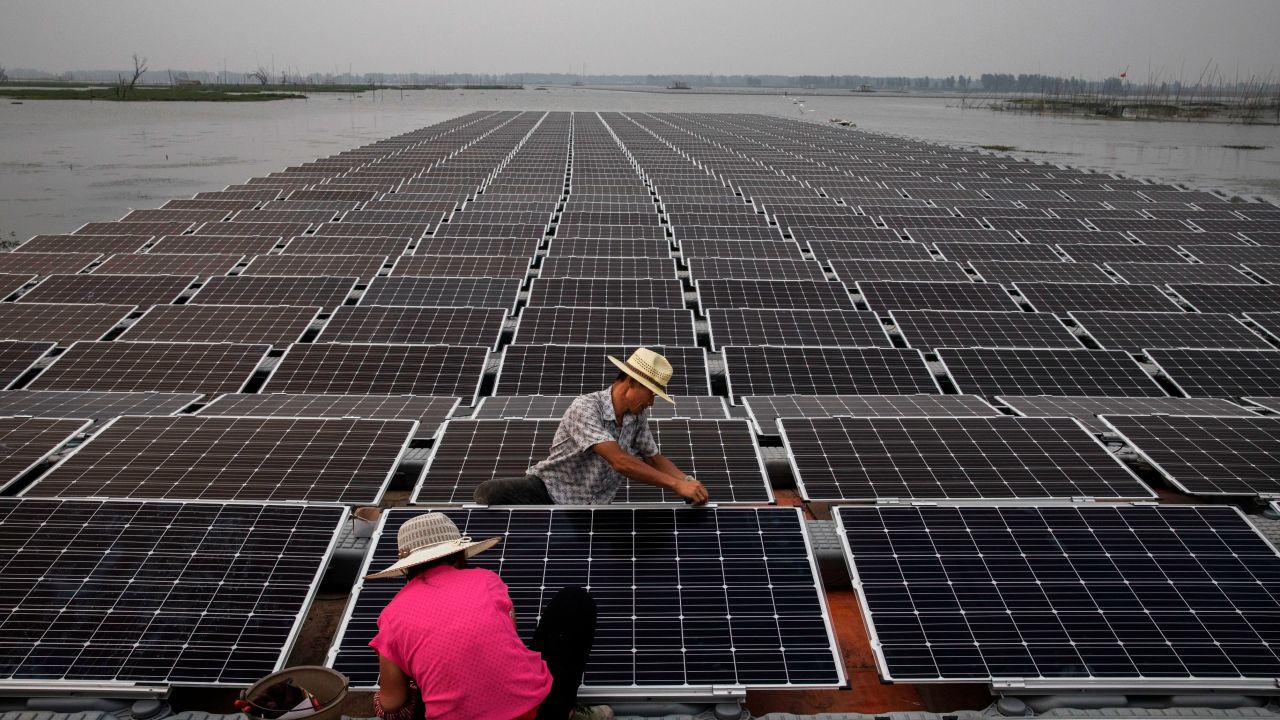 Workers prepare part of a large floating solar farm project under construction in June 2017 in Huainan, Anhui province, China.