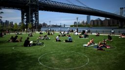 People are seen practicing social distancing in white circles in Domino Park, during the Covid-19 pandemic on May 17, 2020 the in Brooklyn borough of New York City