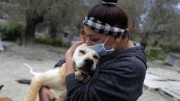 Zaynab Razzouk, head of the animal protection NGO Carma, hugs a dog at the shelter in the area of Koura, north of the Lebanese capital Beirut on April 3, 2020. - According to Razzouk, dogs and cats are getting dumped every day as a result of the outbreak of Covid-19. Razzouk added, that the NGO is flooded with messages from people asking if the shelter can take another unwanted pet. (Photo by JOSEPH EID / AFP) (Photo by JOSEPH EID/AFP via Getty Images)