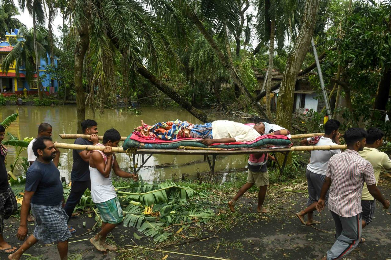 People carry Tapas Pramanik to receive medical treatment after his leg was broken by a fallen tree in Midnapore, India, on May 21.