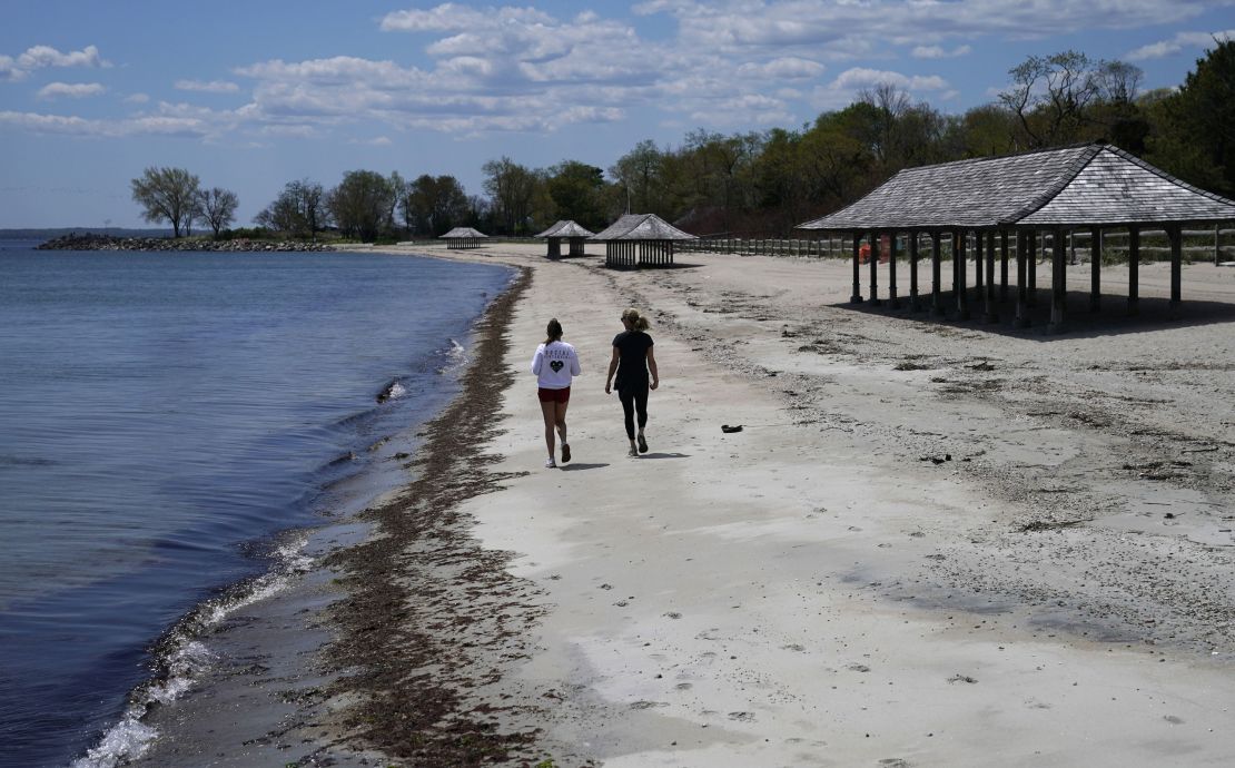 Women walk along the beach on the Long Island Sound on Tod's Point in Old Greenwich, Connecticut on May 7. 