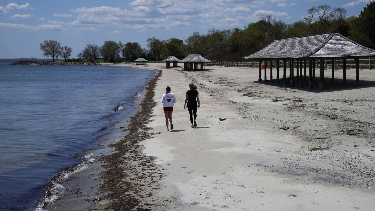 Women walk along the beach on the Long Island Sound on Tod's Point in Old Greenwich, Connecticut on May 7. 