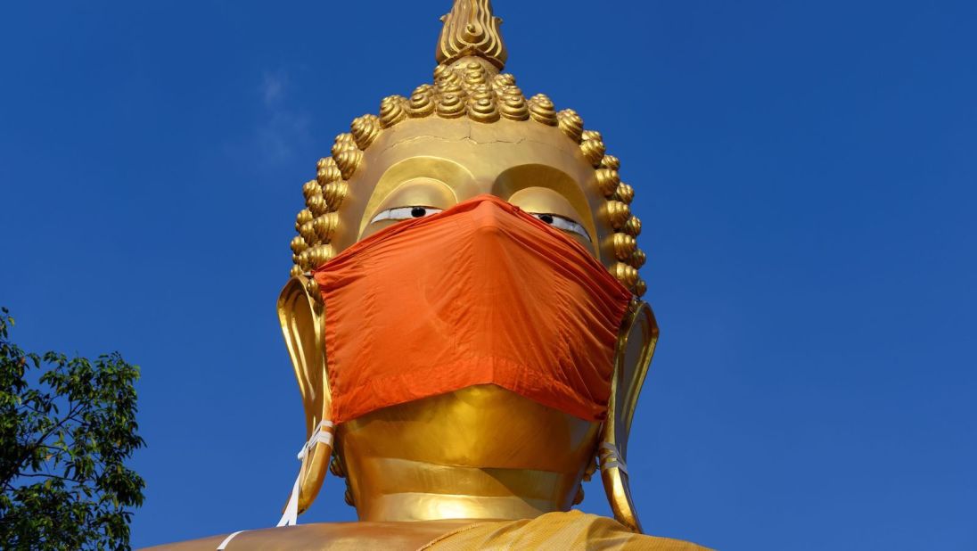 <strong>Sign of the times:</strong> A mask covers the face of a giant Buddha statue at Wat Nithet Rat Pradit temple outside Bangkok. 