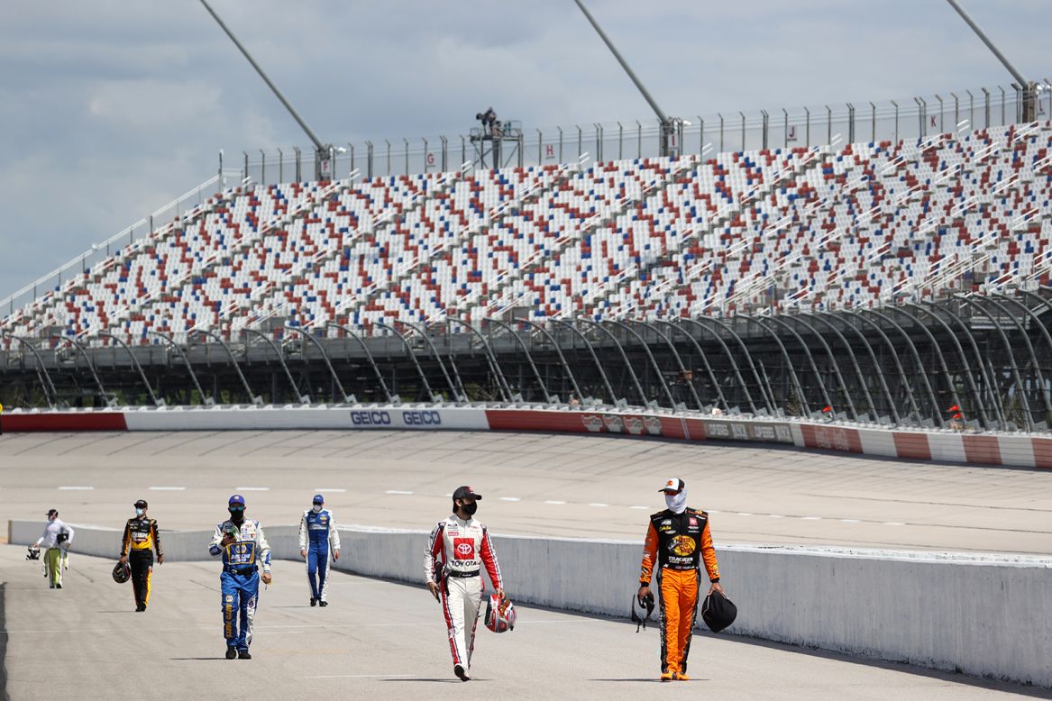 NASCAR drivers walk down the grid before a Cup Series race in Darlington, South Carolina, on Sunday, May 17. It was <a href="https://www.cnn.com/world/live-news/coronavirus-pandemic-05-17-20-intl/h_e8560781fc2629b4a53f4aa0f0623dee" target="_blank">NASCAR's first race</a> since its season was halted because of the pandemic. No fans were in attendance.