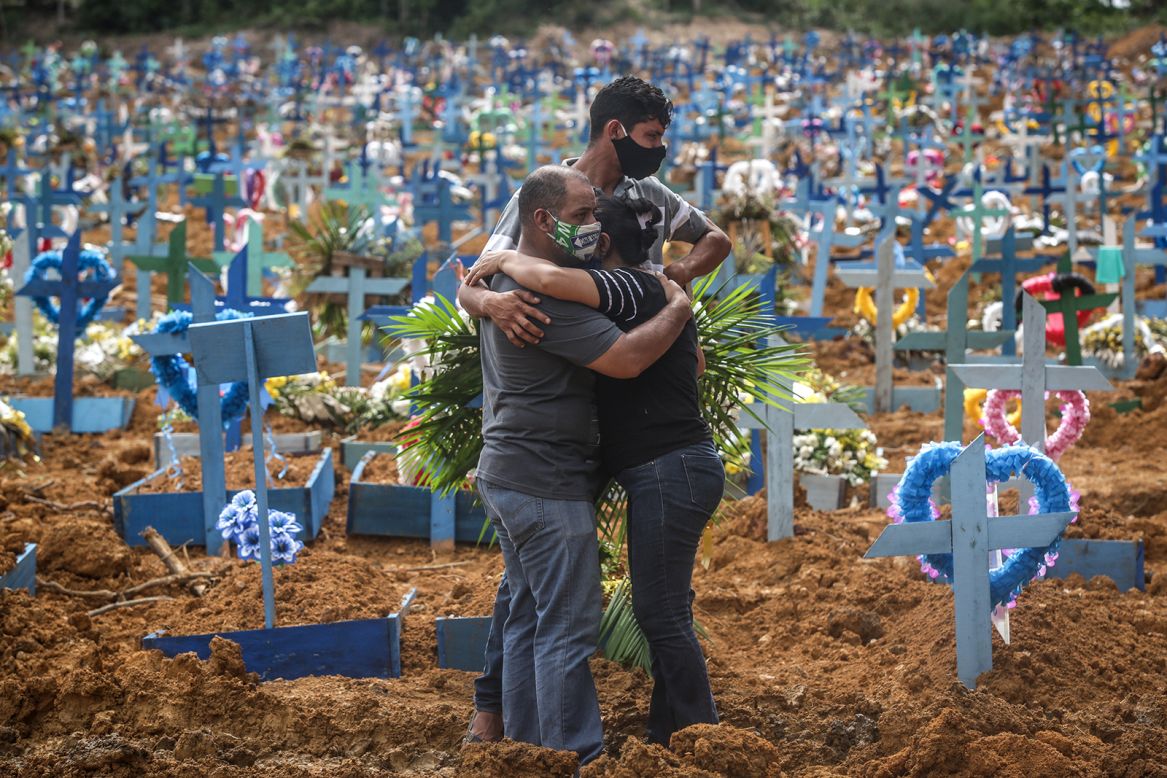 People embrace one another after a mass burial of coronavirus victims in Manaus, Brazil, on Tuesday, May 19. The coronavirus <a href="https://www.cnn.com/2020/05/20/americas/brazil-coronavirus-deaths-intl/index.html" target="_blank">is surging in Brazil,</a> the hardest-hit country in Latin America. It is now third in the world for confirmed cases, behind the United States and Russia.